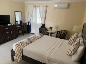 a bedroom with a bed and a desk and a television at Venezia Suites Resort Panglao in Panglao Island