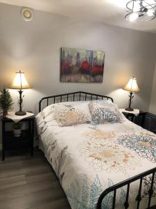 a bedroom with a bed with two lamps and a painting at Mariners Nest in Saint John +25 photos