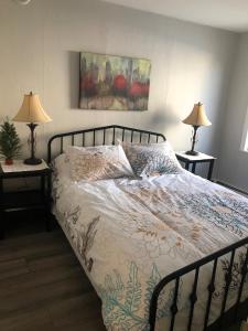 a bed in a bedroom with two lamps on tables at Mariners Nest in Saint John