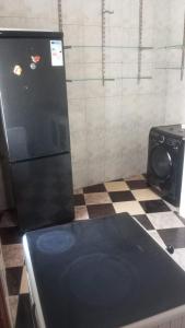 a kitchen with a black refrigerator and a checkered floor at Tetouan city in Tétouan