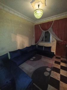 a living room with a blue couch and a checkered floor at Tetouan city in Tétouan +8 photos