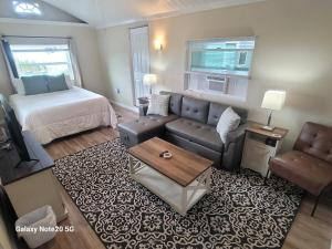 a living room with a couch and a bed at Lazy Oaks Resort Cottages in Leesburg