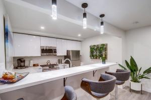 a kitchen with white cabinets and bar stools at Lux Escape 3: Views Spa Games Safari Tent Golf in San Diego