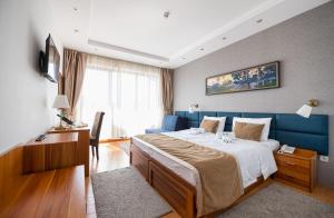 una camera con un grande letto e un divano blu di Iris Zlatibor a Zlatibor Altre 14 foto