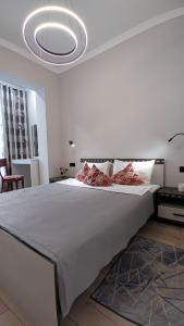 a bedroom with a large white bed with a chandelier at Comfort City 3-Room Apartments in Almaty