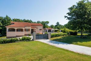 a house with a gate and a grass yard at Villa Božac in Cukrići - Haus für 6 Personen in Svetvinčenat