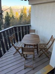 una mesa de madera y sillas en una terraza con mesa y sillas en Studio Mbs Pra Loup, en Uvernet