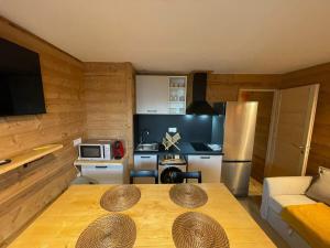 Una sala de estar con una mesa y una cocina. en Studio Mbs Pra Loup, en Uvernet 8 fotos más