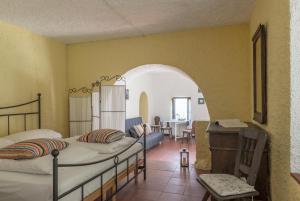 een slaapkamer met 2 bedden en een kamer met een tafel bij Fenil Del Santo in Tremosine Sul Garda