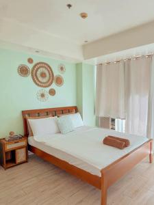 a bedroom with a large bed with white sheets and a window at Azure Staycation by KT in Manila