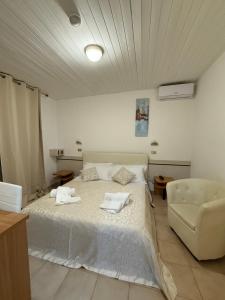 a bedroom with a white bed and a chair at B&B Mima in Milano Marittima