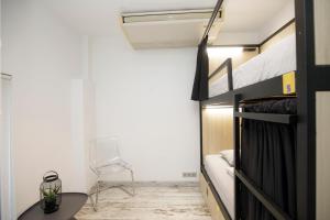 a small bedroom with a bed and a chair at Onefam Sants in Barcelona