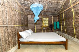 a bed in a small room with a tent at Barramundi in Kalpitiya