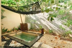 a pool in the middle of a garden at ARKA Tulum in Tulum