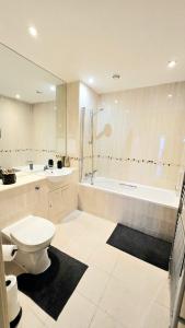 a bathroom with a toilet and a tub and a sink at The ascension 'Ascalon ' in London