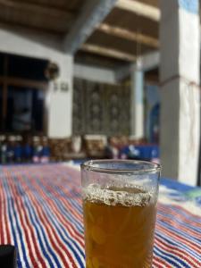 a glass of beer sitting on a table at مأوى الكوف السياحي in M'diq