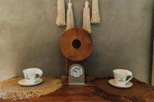 two coffee cups and a clock on a table at ARKA Tulum in Tulum