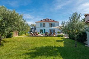 a house with a yard with chairs and trees at Villa Lavanda Allegra in Kanfanar - Haus für 6-8 Personen in Kanfanar