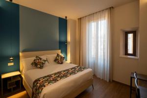 a bedroom with a bed in a room with a window at New Roman Experience in Rome