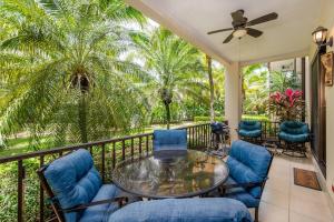 a balcony with a glass table and chairs and palm trees at Pacifico L302 in Coco