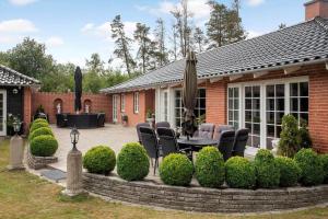una casa con patio con sedie e ombrellone di M392-Gedser-Havrevej-6 a Gedesby