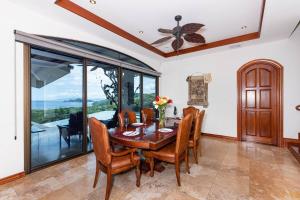 a dining room with a wooden table and chairs at Casa De Los Sueos in Playa Hermosa
