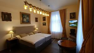 a bedroom with a bed and a table and a window at Luxury Gato View Apartment Karlovy Vary with private parking in Karlovy Vary