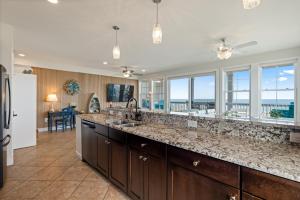 a kitchen with a large counter top and windows at SC304 - Top of the Banx in Kill Devil Hills