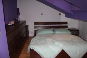 プラハにあるSunny Two-story Apartment Kyjeの紫色の天井のベッドルーム1室(大型ベッド1台付)
