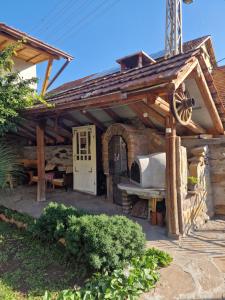 an outdoor kitchen with a wooden pergola at Apartman Tupavica in Pirot