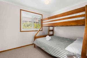 a bedroom with a bunk bed and a window at Blenheim Hideaway by Experience Jervis Bay in Vincentia