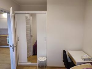Un dormitorio con una puerta corrediza de vidrio con un pequeño taburete. en Apartament Jasny Spokój, en Jantar