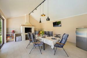 una sala da pranzo con tavolo, sedie e camino di Villa Mendula in Čambarelići - Haus für 6-7 Personen a Kršan