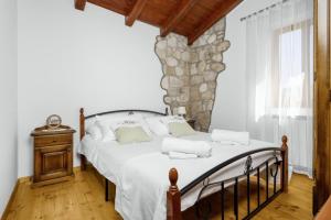 une chambre avec un grand lit avec un mur en pierre dans l'établissement Casa Regina in Kršan - Haus für 6 Personen, à Kršan
