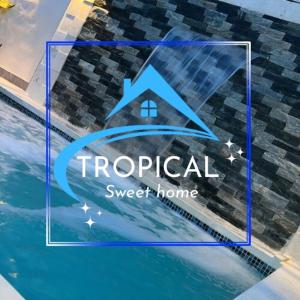 a sign that reads tropical sweet home next to a swimming pool at Lujosa casa con piscina privada in Los Frailes