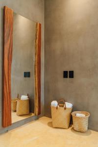 a mirror with three baskets in a room at ARKA Tulum in Tulum