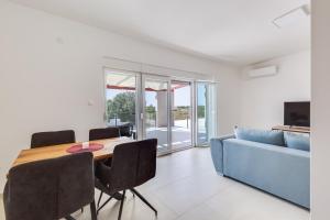 une salle à manger avec une table et un canapé bleu dans l'établissement Villa Kotari in Zemunik Gornji - Haus für 10-12 Personen, à Simurina