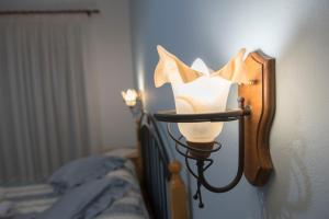 a lamp on a wall next to a bed at Nephele Apartments in Faliraki