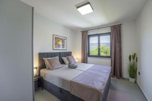 ein Schlafzimmer mit einem großen Bett mit Fenster in der Unterkunft Villa Milena in Blaškovići - Haus für 8 Personen in Polje Čepić + 36 Fotos