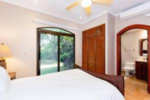 a bedroom with a bed and a bathroom with a window at Mariners Point C1 3br Ocean-view Private Pool in Playa Hermosa +35 photos