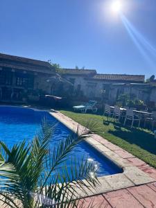 a swimming pool in a yard with tables and chairs at Le petit Olivier 