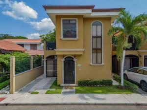 una casa amarilla con un coche aparcado delante en One Particular Harbor 2br Townhouse 4 Guests, en Coco