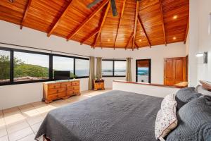 a bedroom with a bed and a television and windows at Vista Oceano in Playa Hermosa +49 photos