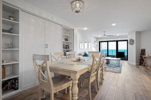 Una cocina y un comedor con mesa y sillas. en Stunning direct oceanfront condo with a balcony, hot tub, and heated pool, en Bottle Island