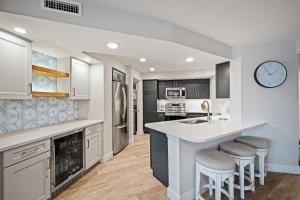Una cocina con encimera y taburetes. en Stunning direct oceanfront condo with a balcony, hot tub, and heated pool, en Bottle Island