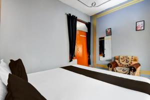 a bedroom with a bed and a chair in it at Hotel Stay Inn in Lucknow