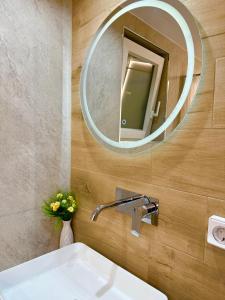 a bathroom with a sink and a mirror at VERORE aprtm in Chalkida +36 photos