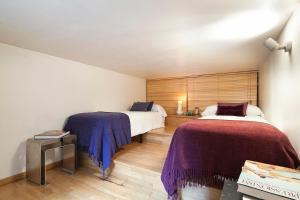 um quarto com 2 camas e cobertores roxos em Apartment Barcelona Rentals - Park Güell Apartments em Barcelona