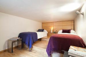 1 dormitorio con 2 camas y mantas moradas en Apartment Barcelona Rentals - Park Güell Apartments, en Barcelona