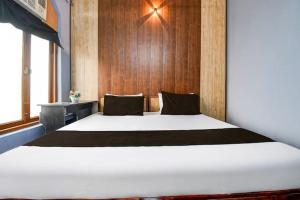 a large white bed in a room with a wooden wall at Hotel Stay Inn in Lucknow
